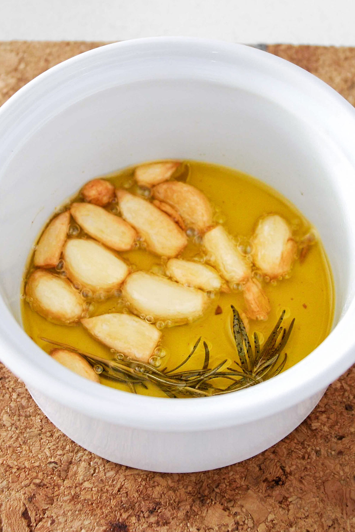 Freshly roasted garlic and rosemary in an oven-safe pot.