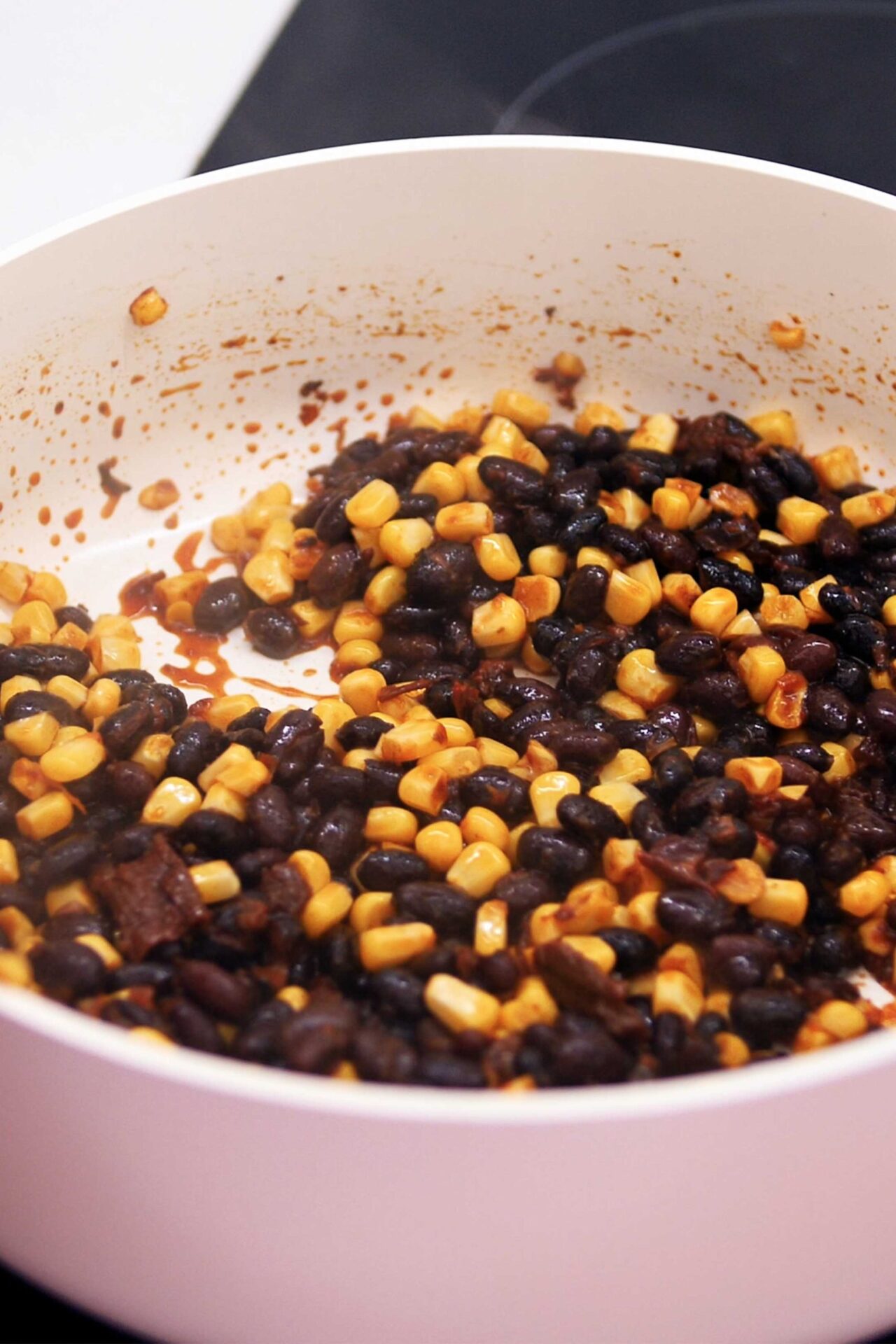 a bean and corn mixture in a pan for a black bean tacos recipe