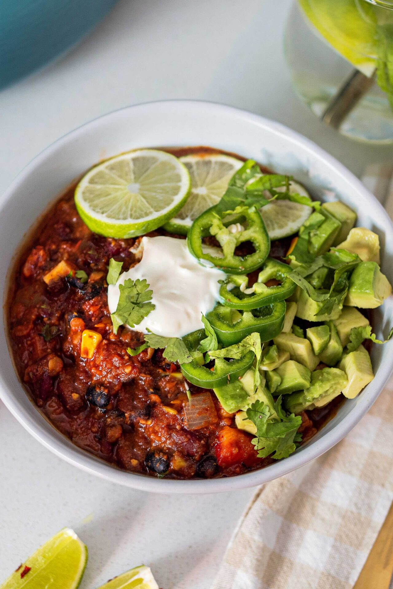 Image of a bowl of 3-bean chili with toppings. The image is appetizing and showcases a comforting and flavorful vegetarian chili option.