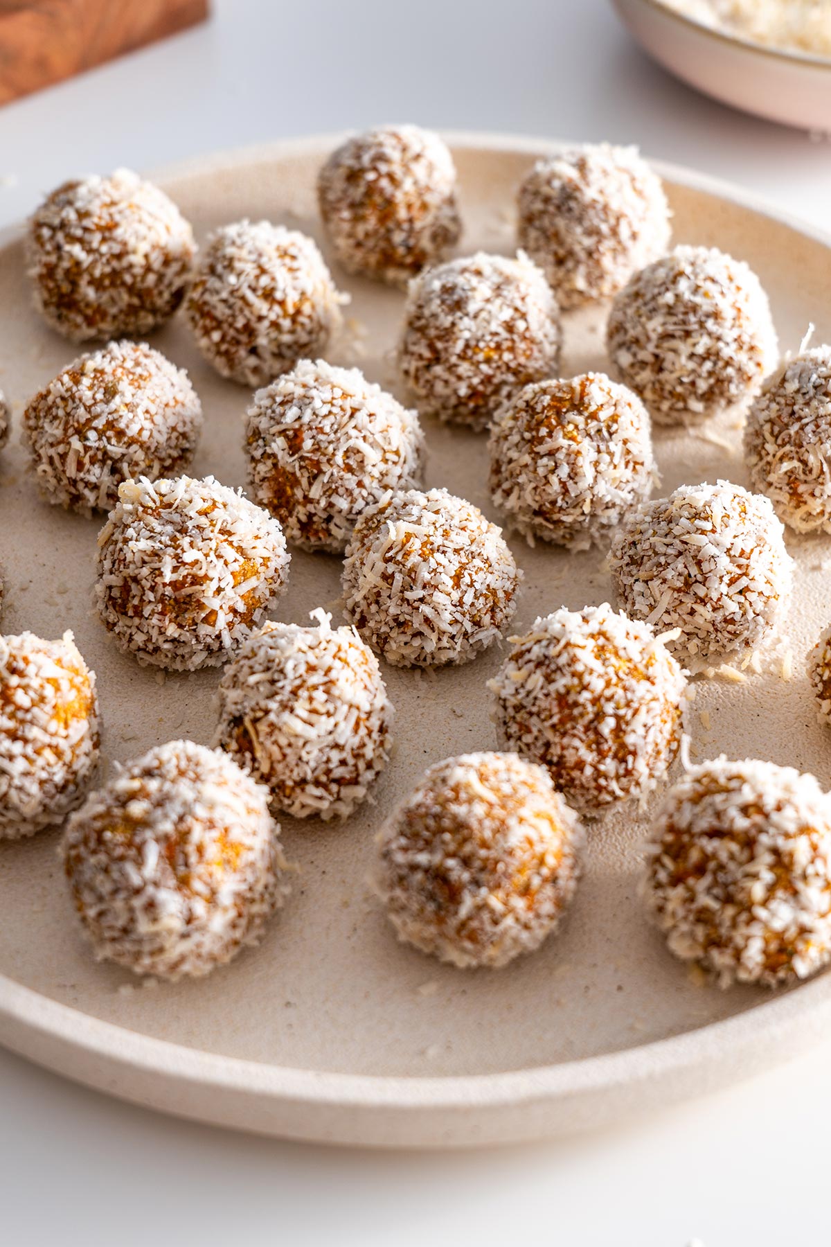 Carrot Cake Bliss Balls on a plate with a light background.