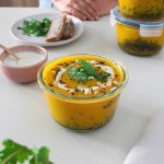 Carrot ginger and lentil soup in containers, a perfect meal-prep option.
