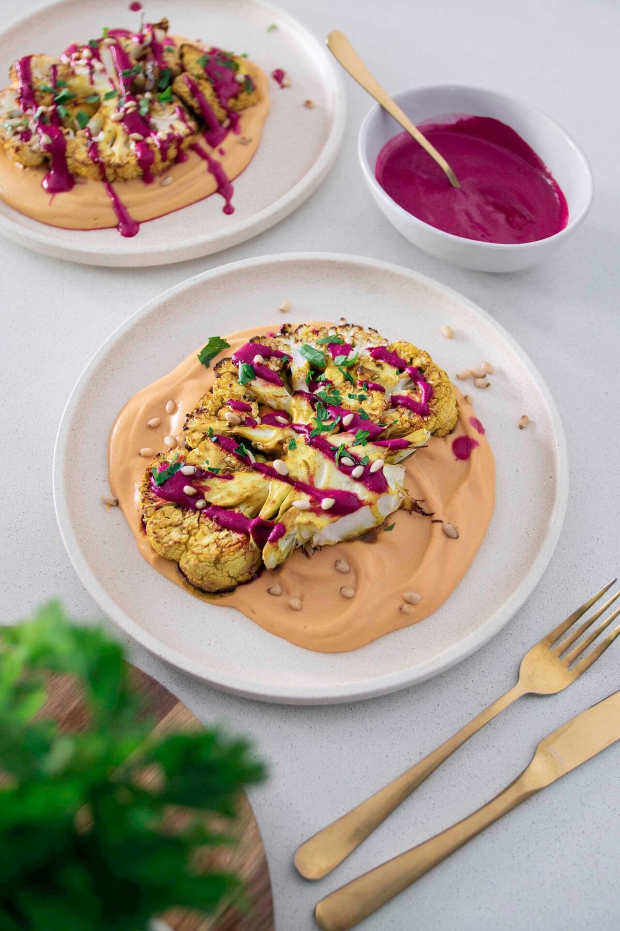 Sunset Cauliflower Steak - A mouthwatering vegan dish featuring a thick slice of roasted cauliflower, seasoned with aromatic spices and served with a vibrant sunset-colored sauce.