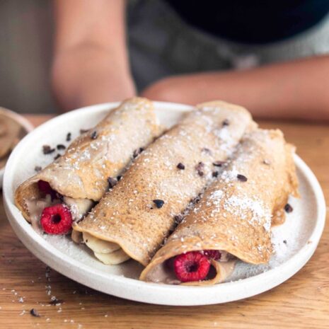 A plate of Delicious vegan French Crepes covered in cacao and coconut