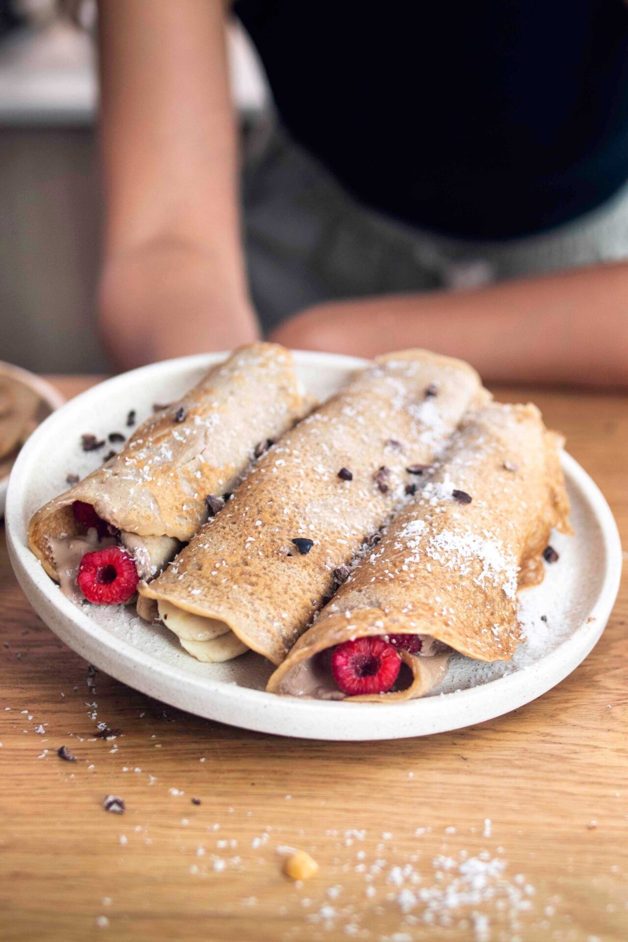 A plate of Delicious vegan French Crepes covered in cacao and coconut