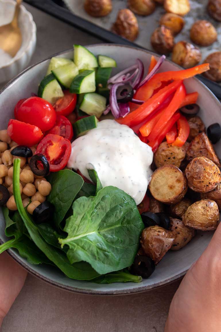 A beautifully arranged bowl filled with vibrant and colorful ingredients inspired by Greek mythology. This Greek Goddess Bowl features a bed of fluffy quinoa topped with fresh and crisp cucumber slices, juicy cherry tomatoes, creamy feta cheese, tangy Kalamata olives, and a sprinkle of fragrant herbs. Drizzled with a zesty lemon dressing, this bowl is a divine combination of flavors and textures that will transport you to the Mediterranean.