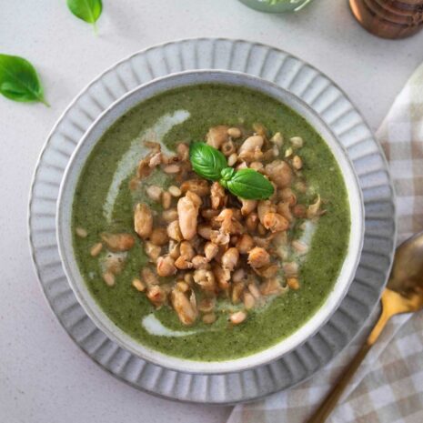 A bowl of rustic green goddess soup, garnished with fresh herbs