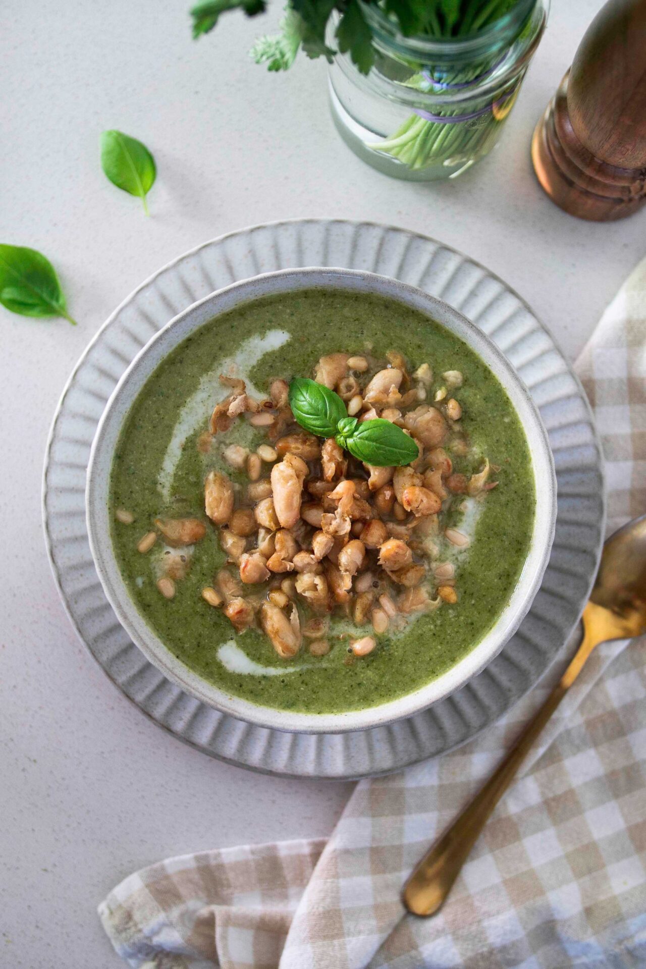 A bowl of rustic green goddess soup, garnished with fresh herbs