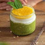 A jar of matcha overnight oats topped with fresh mint