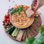 Mediterranean Crackers and dip on a wooden serving board