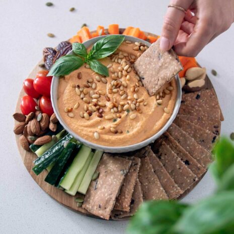 Mediterranean Crackers and dip on a wooden serving board