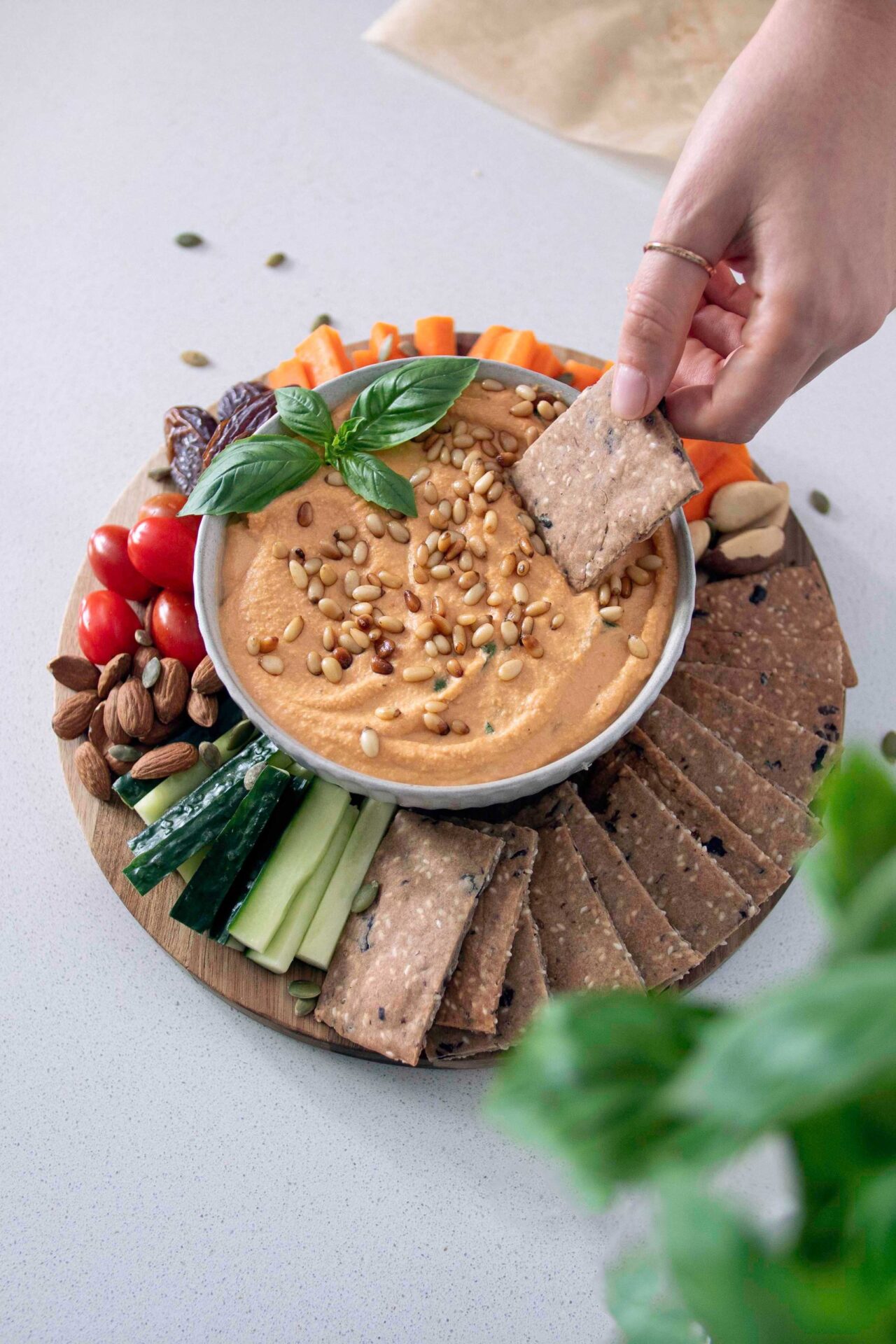 Mediterranean Crackers and dip on a wooden serving board