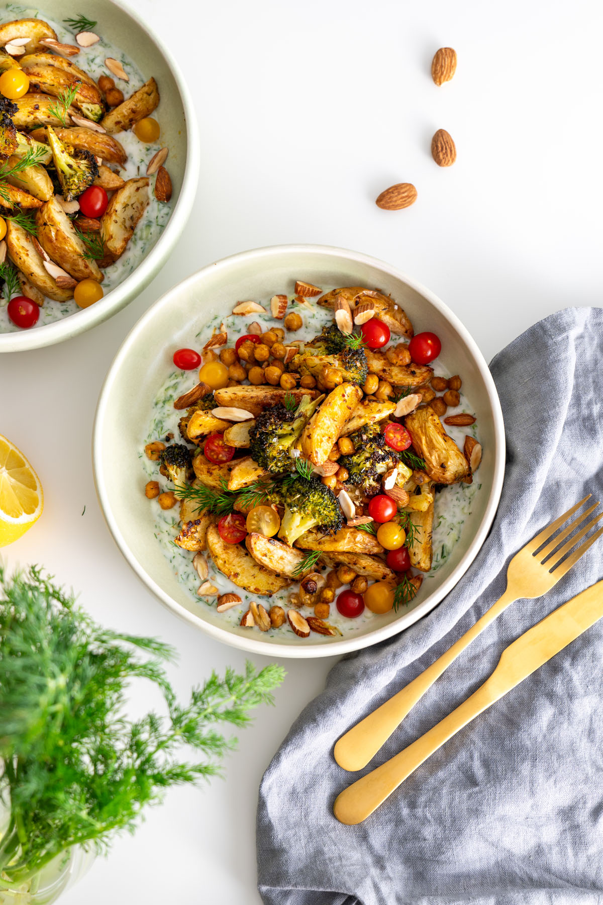 Overhead view of a vibrant bowl of roasted vegetables and chickpeas on tzatziki.