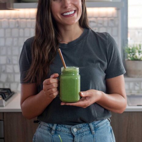 Sarah of plantbaes with a vibrant green smoothie for women's health