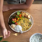 Vibrant plate, full of potatoes, veggies, and a plant-based omelette