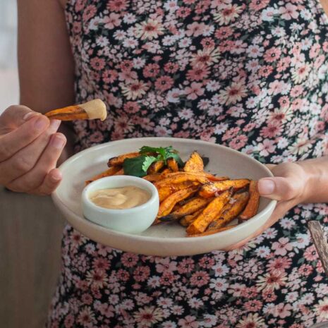 A mouthwatering image of creamy and flavorful cashew queso, perfect for dipping sweet potatoes or drizzling over nachos.