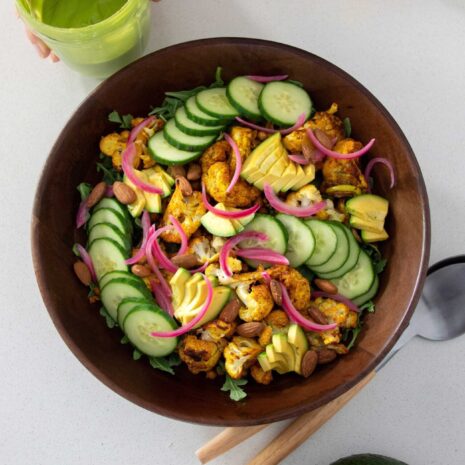 Vibrant, healthy roasted cauliflower and avocado salad in a wooden salad bowl
