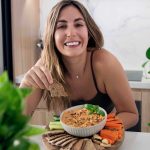 Mediterranean sun-dried tomato dip served in a bowl with crackers and fresh vegetables.