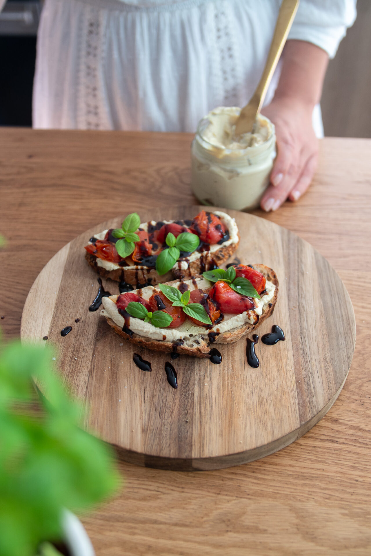 Sourdough with tofu, cream cheese, spread and tomatoes on a wooden serving board