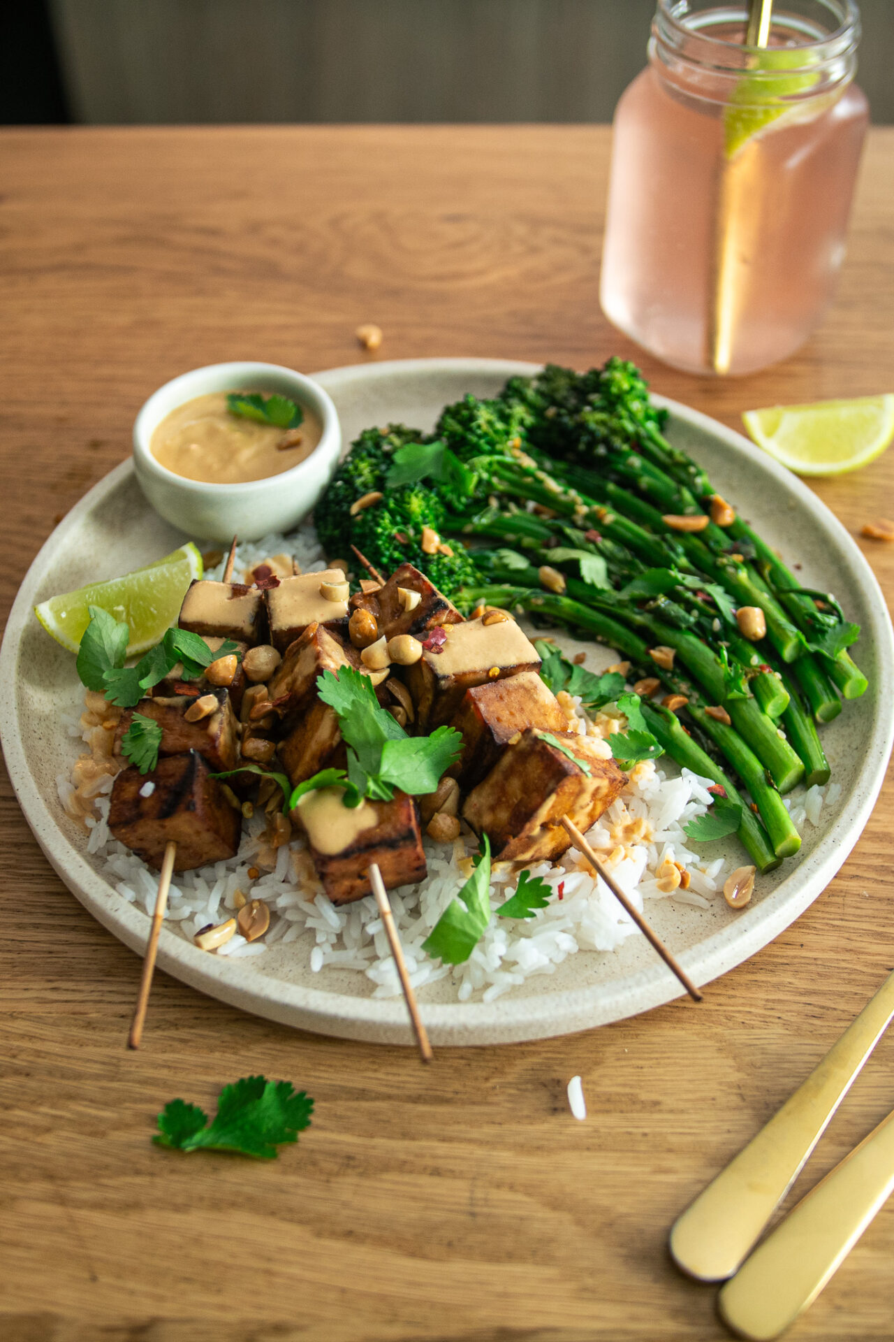 Tofu satay skewers on a bed of rice with broccolini