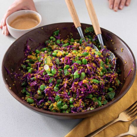 Turmeric quinoa & edamame salad in a bowl with salad dressing