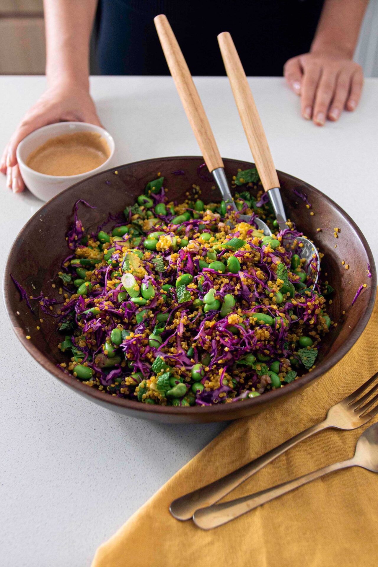 Turmeric quinoa & edamame salad in a bowl with salad dressing