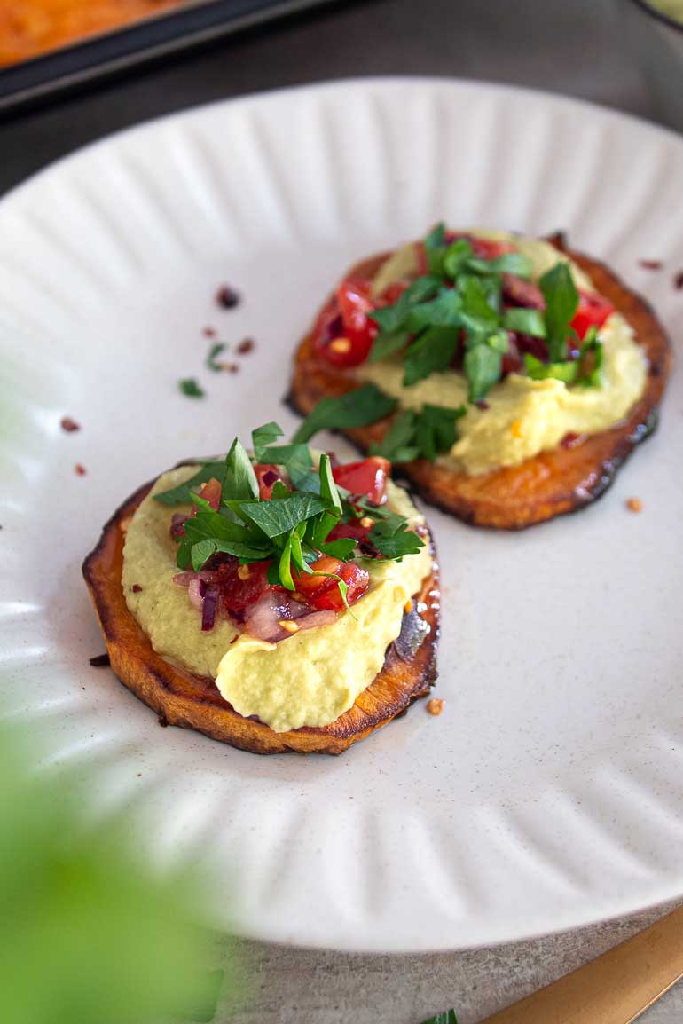 Avocado hummus spread on slices of sweet potato toast.