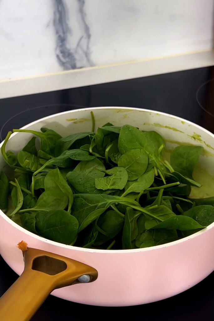 Big mound of fresh spinach in pot of Butter Bean Pesto