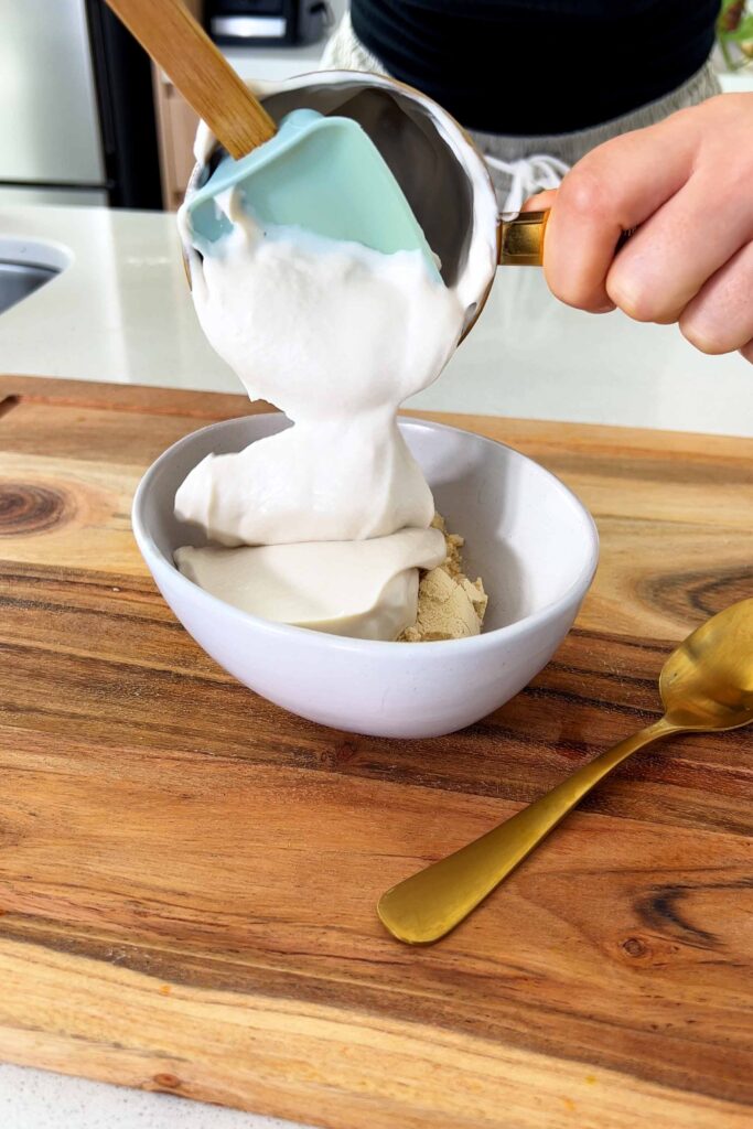 Making the Carrot Cake Baked Oats icing with soy yogurt and protein powder in a bowl