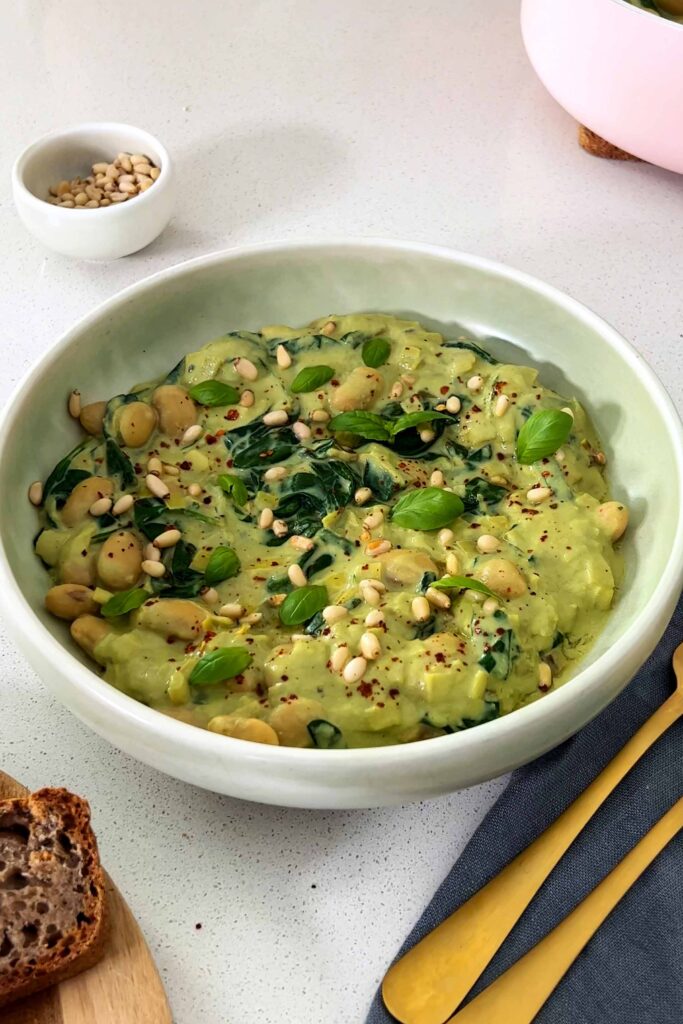 Butter bean pesto bowl with pine nuts and buckwheat bread on the side