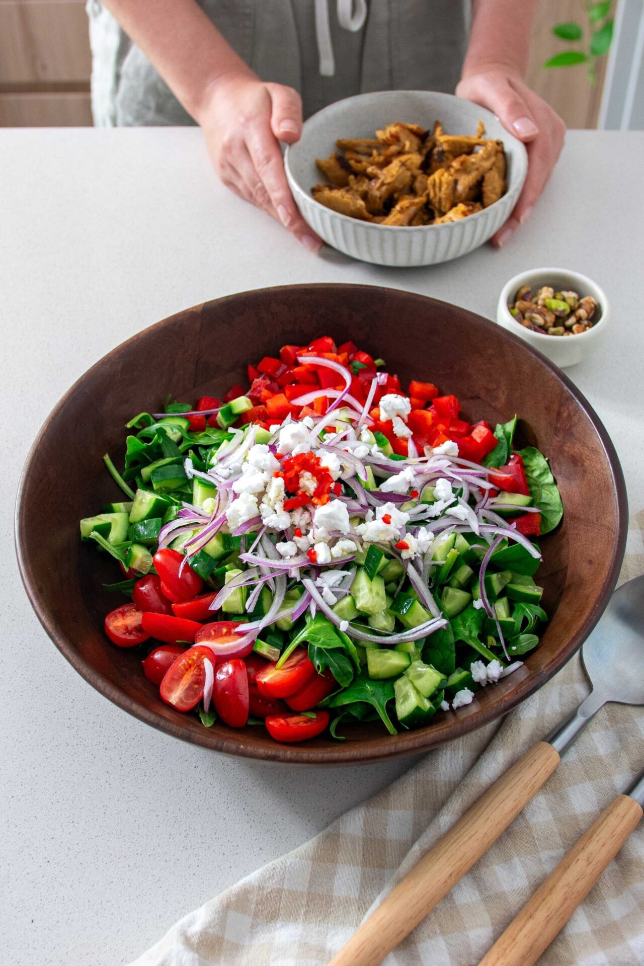 Big wooden salad bowl full of vibrant tomatoes, cucumber and veggies based on Florence Pugh's Salad