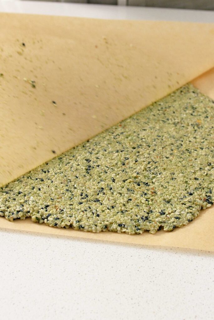 Baking paper being removed from flattened crackers mix