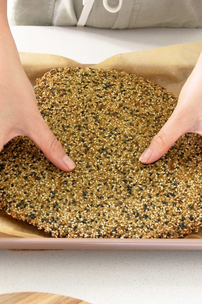 Sarah holding the cracker mix that has completed baking