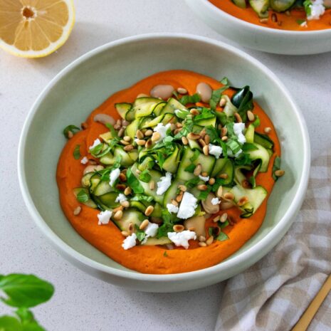 A bowl of vibrant, healthy Zucchini and butter bean salad on a Romanesco-inspired sauce