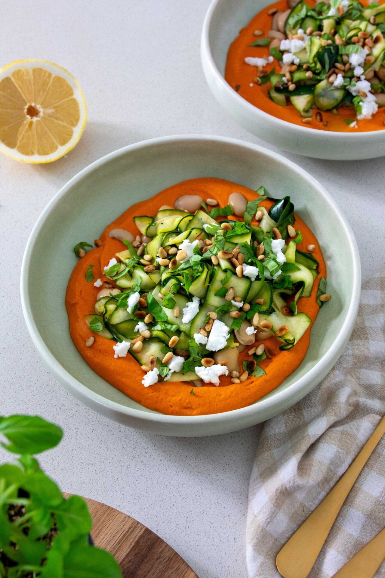 A bowl of vibrant, healthy Zucchini and butter bean salad on a Romanesco-inspired sauce