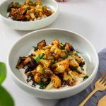 Mediterranean-style bowl of roasted harissa cauliflower with garlic confit dip