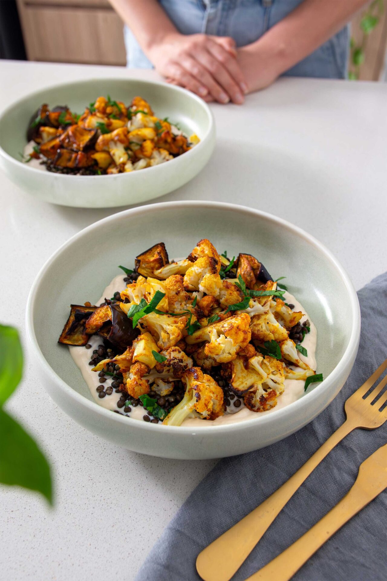 Mediterranean-style bowl of roasted harissa cauliflower with garlic confit dip