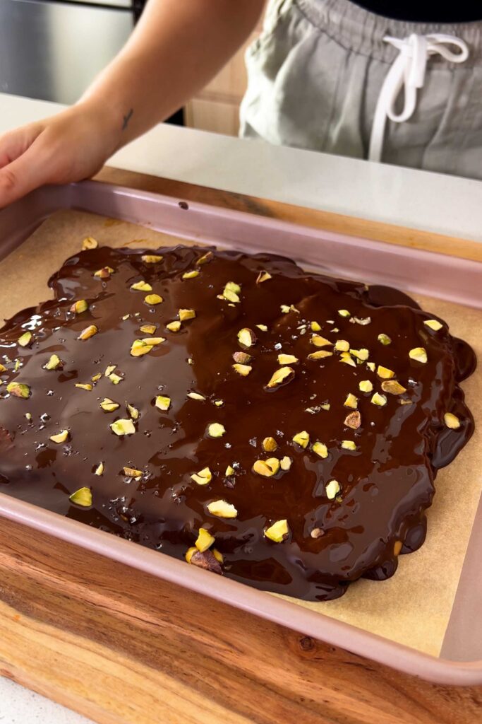 Final shot of the date bark with melted chocolate and toppings ready to be put in the fridge