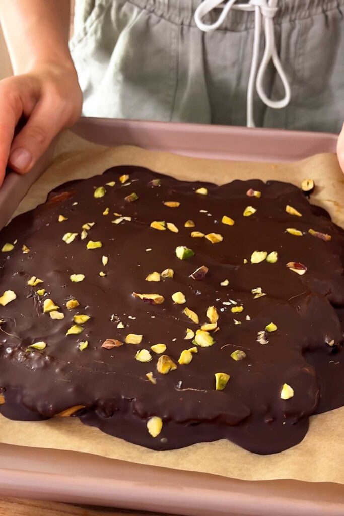 The viral chocolate date bark fresh out of the fridge with layer of pistashios and sea salt