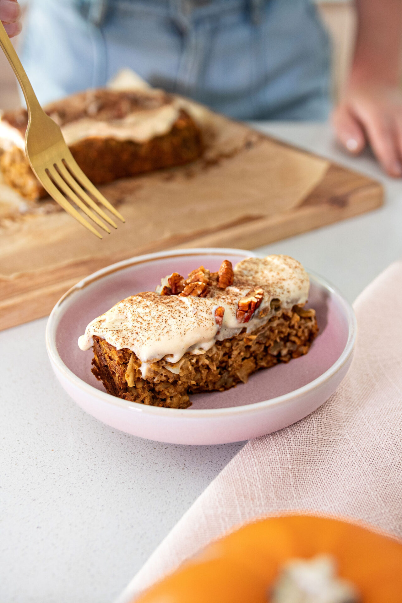 A slice of freshly baked plant-based Pumpkin Spice Baked Oats in a bowl with a fork about to dive in
