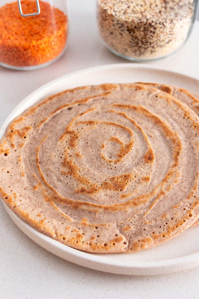 Quinoa and red lentil wraps stacked on a plate