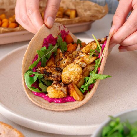 Vibrant, veggie packed quinoa and red lentil wrap being rolled