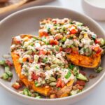 Close-up of Roasted Sweet Potato Tabbouleh Bowl garnished with seeds and dressing