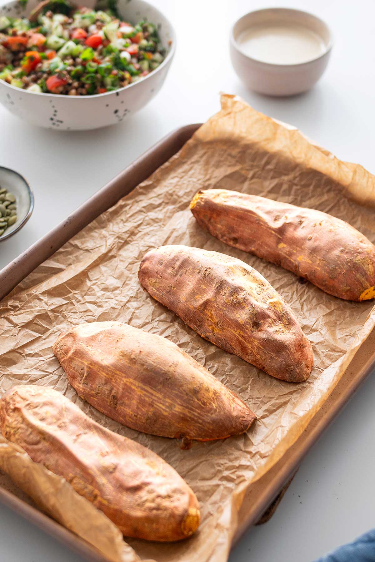 Roasted sweet potatoes on a baking sheet, ready for Tabbouleh topping.