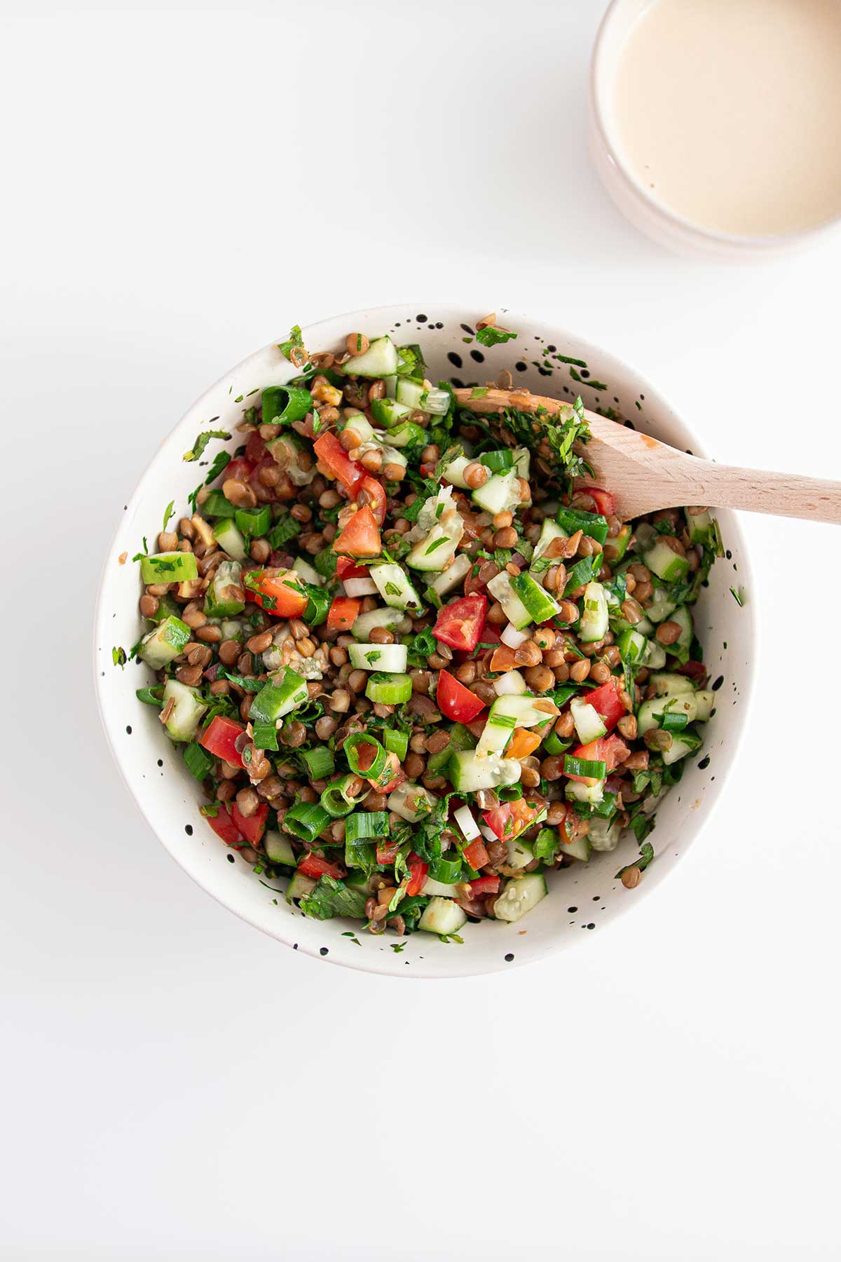 Freshly mixed Tabbouleh with lentils, tomatoes, and herbs for Sweet Potato Bowl.