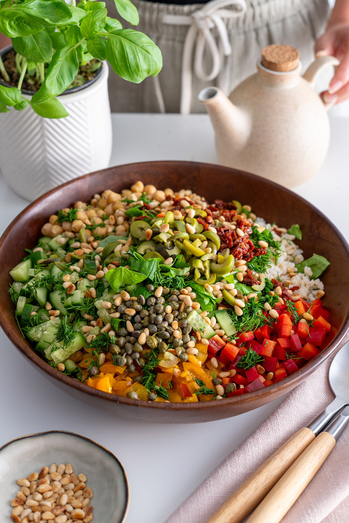 Colorful Mediterranean chopped salad in a wooden bowl, ready to be tossed.