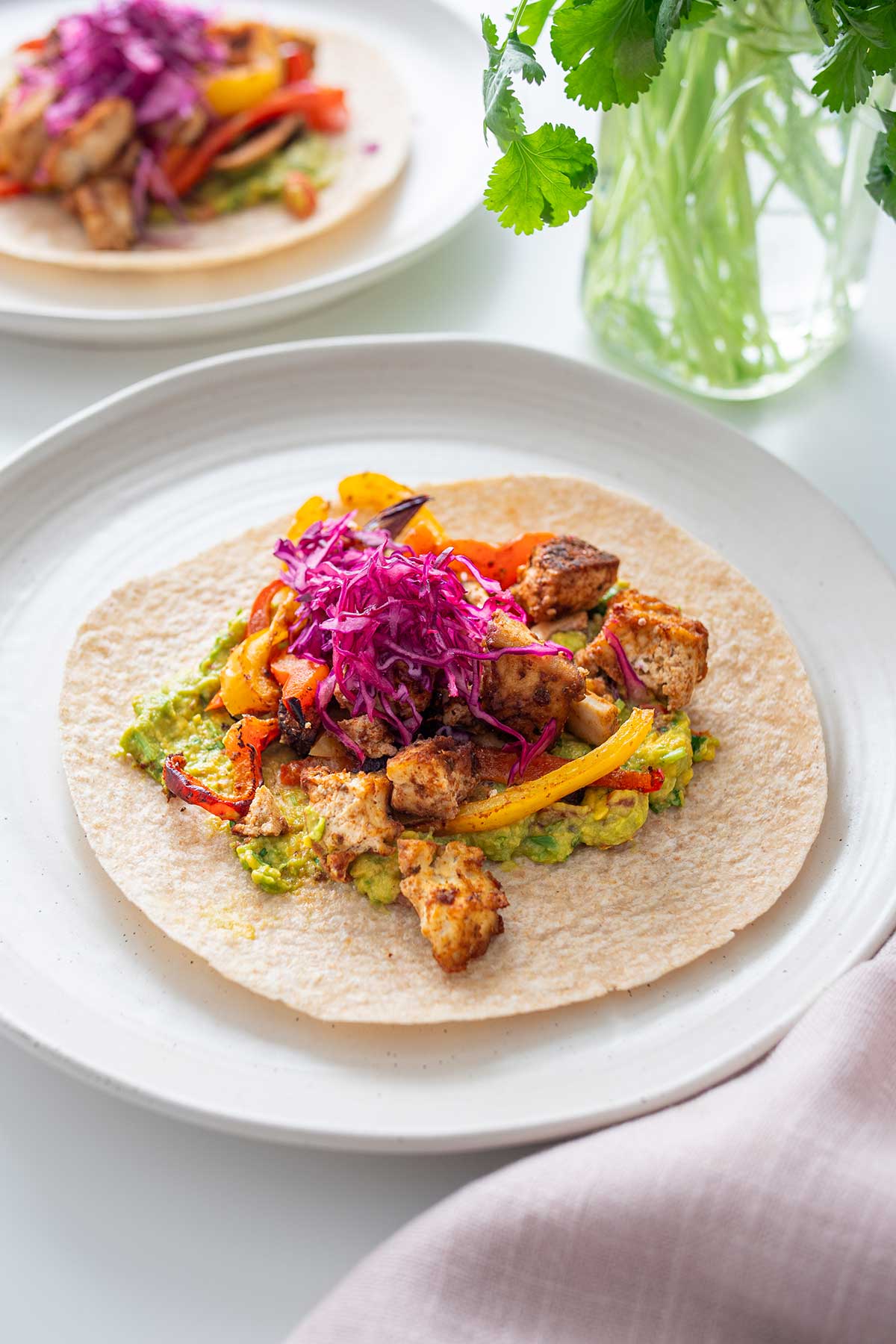 A close-up view of a vibrant vegan sheet pan fajita, highlighting the colorful vegetables and spices.
