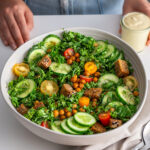 Finished High-Protein Kale Caesar Salad in a white bowl on a kitchen table.