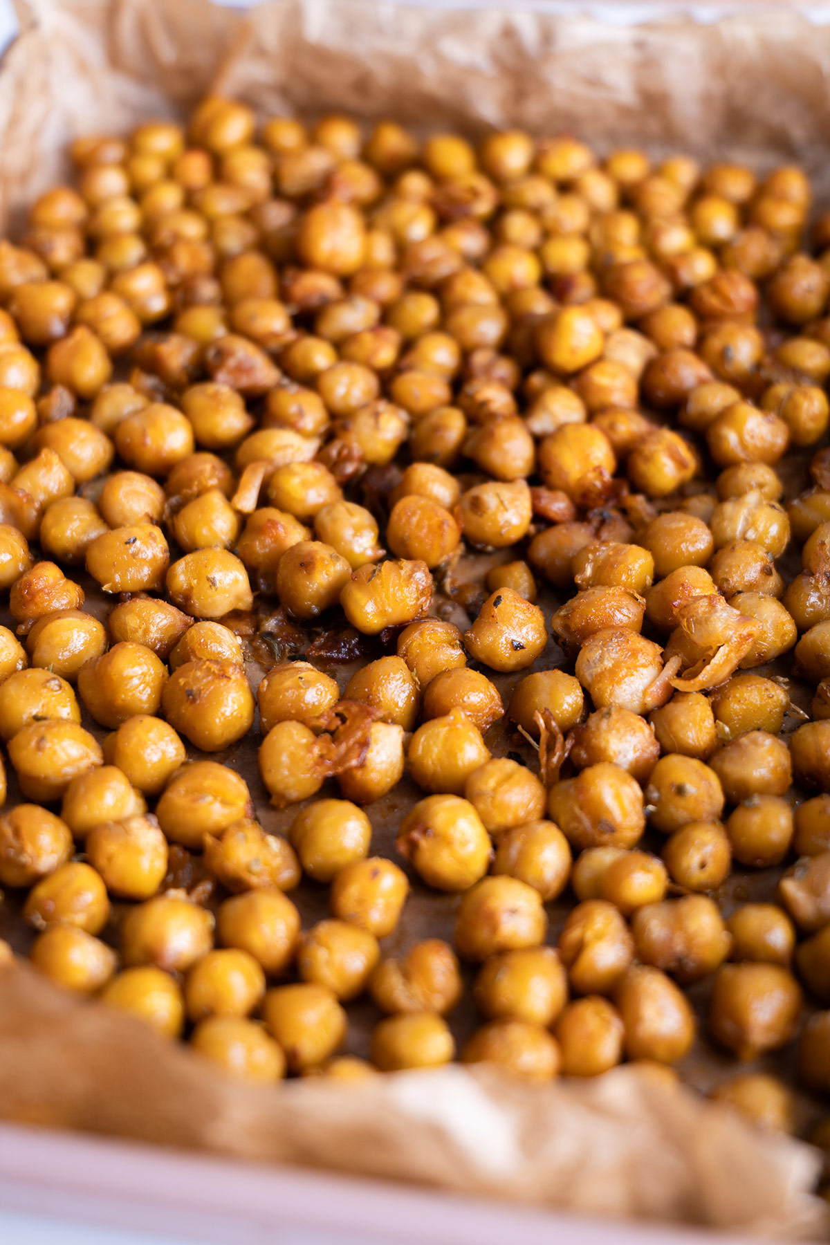 Oven-roasted spiced chickpeas on baking paper, ready for salad topping.