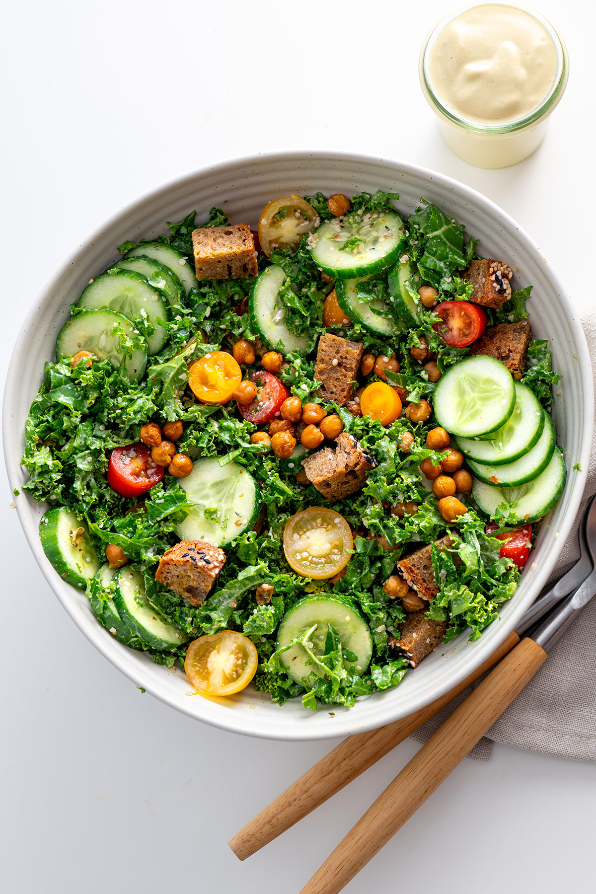 Top-down view of High-Protein Kale Caesar Salad with colorful tomatoes and crunchy croutons.