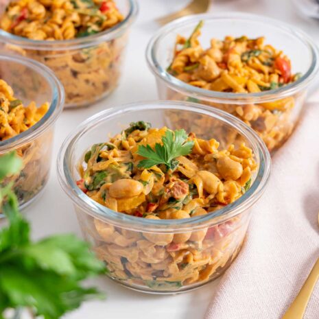 Glass bowls of 'High-Protein Vegan Marry Me Pasta' meal prepped and garnished with parsley.